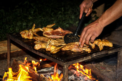 Person preparing food on barbecue grill