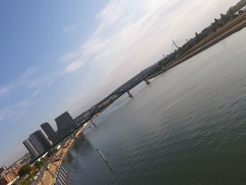 Aerial view of buildings by sea against sky