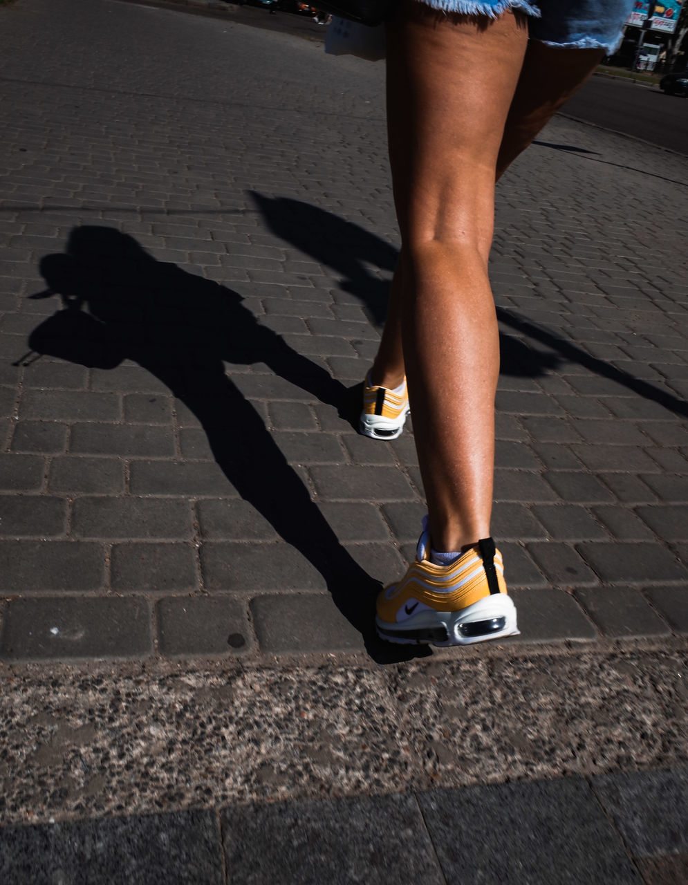 low section, human leg, body part, human body part, shadow, real people, lifestyles, sunlight, city, day, one person, leisure activity, shoe, footpath, street, nature, outdoors, walking, standing