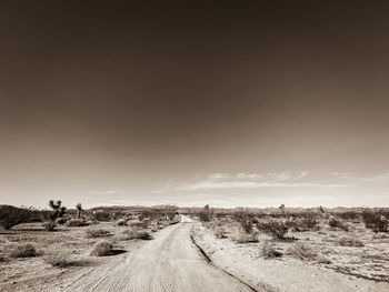 Road amidst field against sky