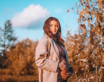 Woman standing by tree during autumn