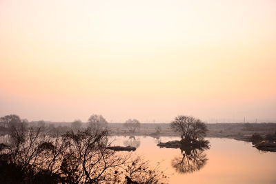 Scenic view of lake against orange sky