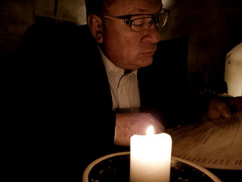 Portrait of man with candles on table