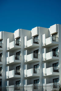Low angle view of modern building against clear blue sky