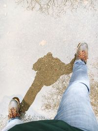 Low section of person standing in puddle