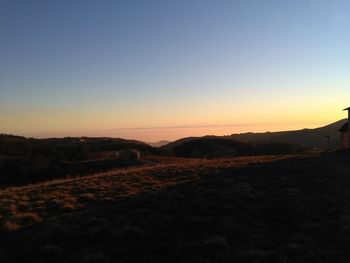 Scenic view of silhouette landscape against clear sky during sunset