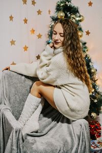 Young woman smiling while sitting at home