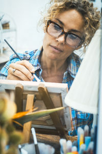 Portrait of woman using digital tablet while sitting on table