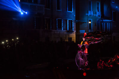 People walking on illuminated street at night