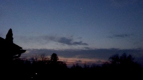 Silhouette trees against sky at dusk