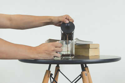 Midsection of person holding drink against white background