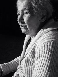 Thoughtful senior woman looking away while sitting outdoors