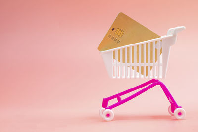 High angle view of small shopping cart against white background