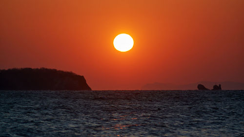 Scenic view of sea against orange sky