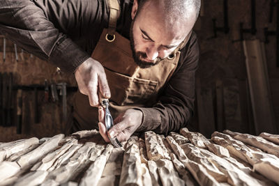 Man carving wood on table at workshop