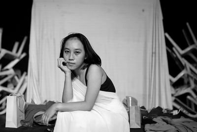 Portrait of young woman sitting on chair