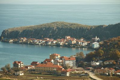 High angle view of sea and cityscape against sky