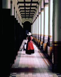 Rear view of woman walking on corridor of building