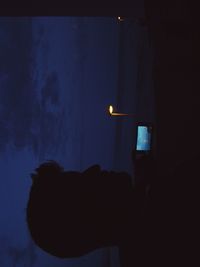 Close-up of illuminated lamp against sky at night