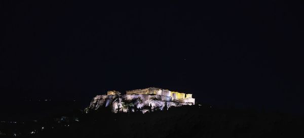 Illuminated buildings against sky at night