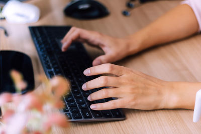 Midsection of person using smart phone on table