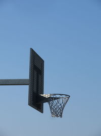 Low angle view of basketball hoop against clear blue sky