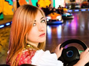 Portrait of woman sitting in bumper car at amusement park