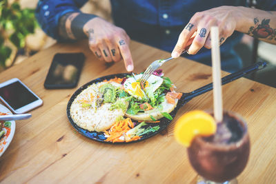 Midsection of man eating meal on table