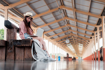 Woman sitting on ceiling in corridor