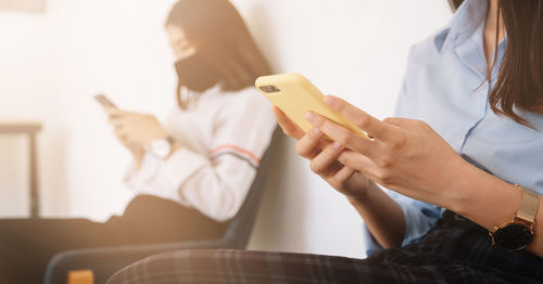 Midsection of woman using mobile phone