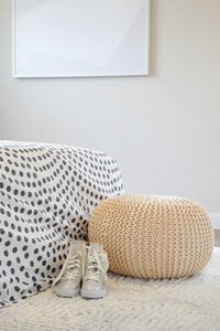 Close-up of shoes on bed against wall at home