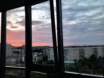 Buildings in city against sky during sunset