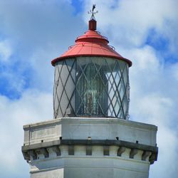 High section of lighthouse against clouds