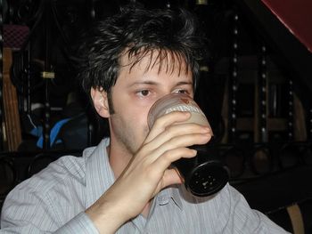 Close-up portrait of a man drinking glass