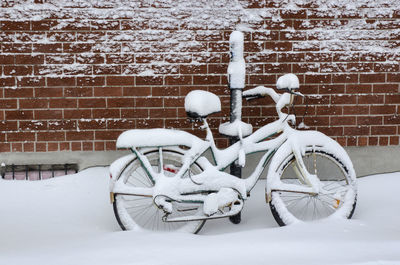 Bicycle on snow covered wall
