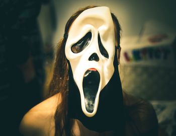 Close-up of woman wearing mask at home