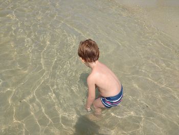 High angle view of shirtless boy in swimming pool