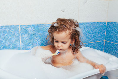 Boy in bathtub at home