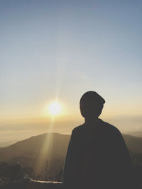 Silhouette man standing against sky during sunset