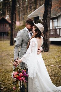 Couple with bouquet embracing in forest