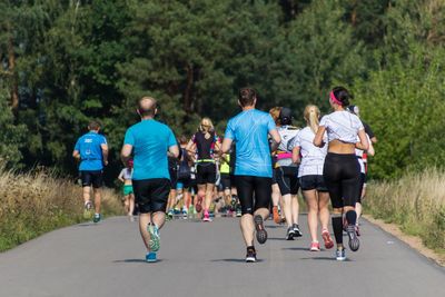 Rear view of people walking on road