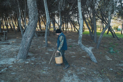 Rear view of woman standing in forest