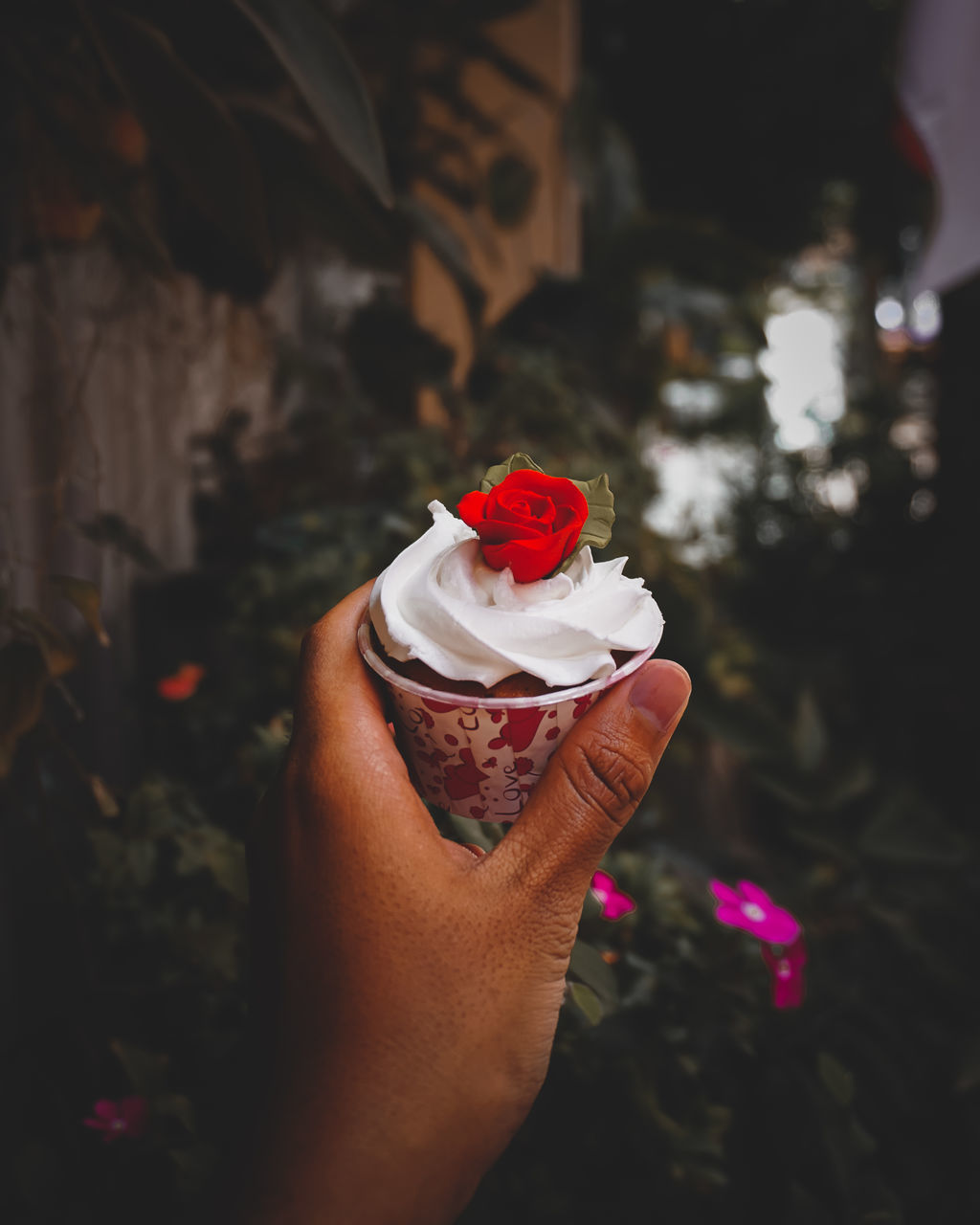 CLOSE-UP OF HAND HOLDING ROSE IN RED ROSES