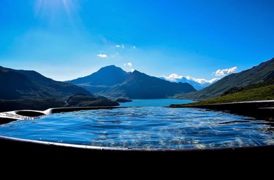 Scenic view of lake and mountains against blue sky