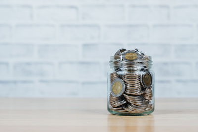 Close-up of coins in jar on table