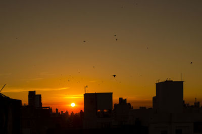 Silhouette buildings against sky during sunset