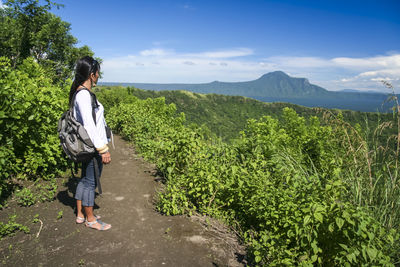 Woman standing on mountain against sky