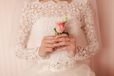 Midsection of bride holding bouquet