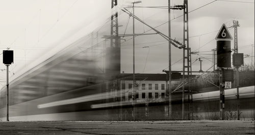 Blur image of train by building against sky
