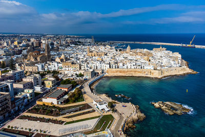 High angle view of cityscape by sea against sky